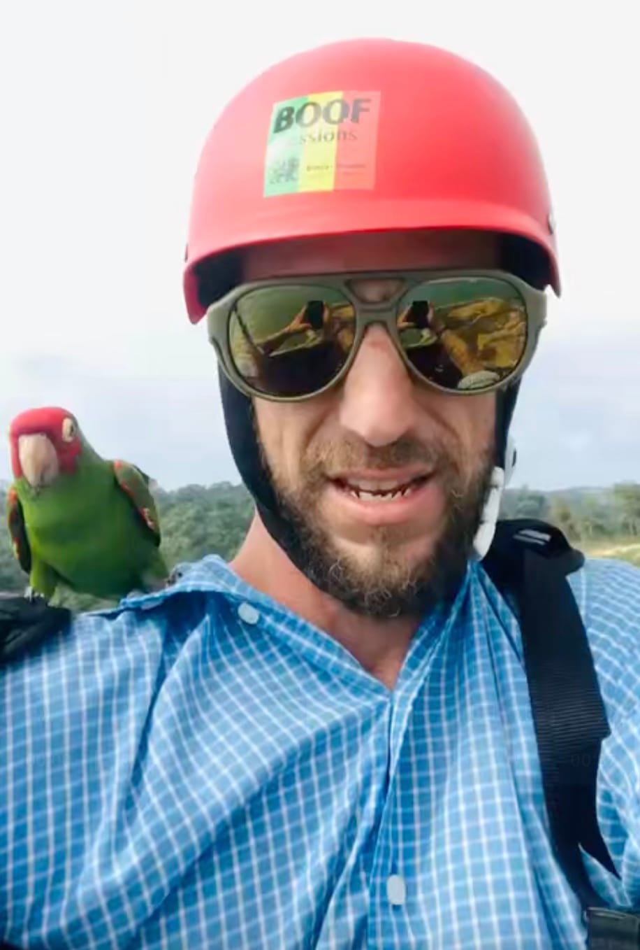 Peter Stromberg in a helmet getting ready to paraglide off the cliffs of insanity around Canoa. He's got a parrot on his shoulder.